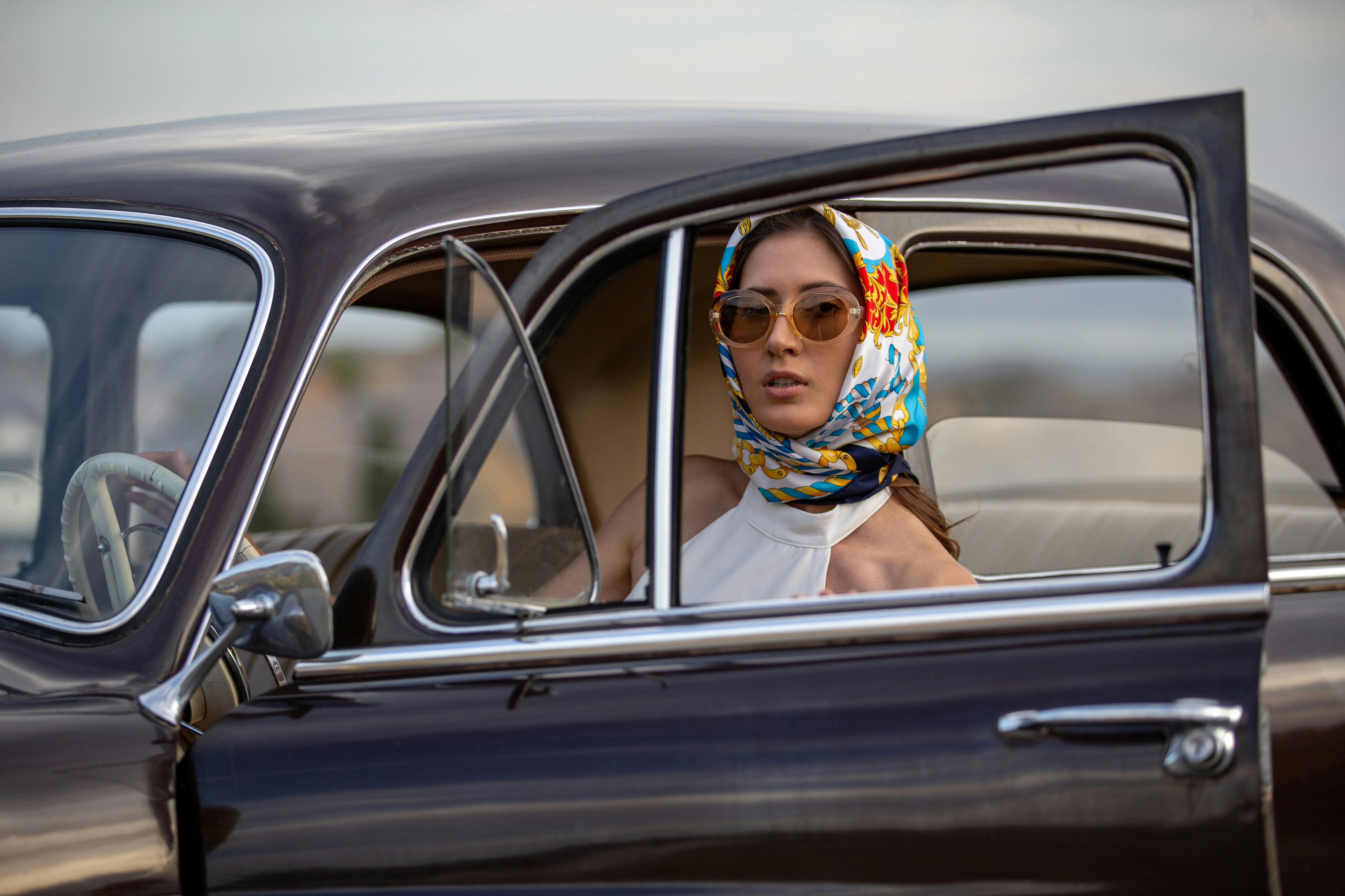 woman in white sleeveless dress wearing brown sunglasses